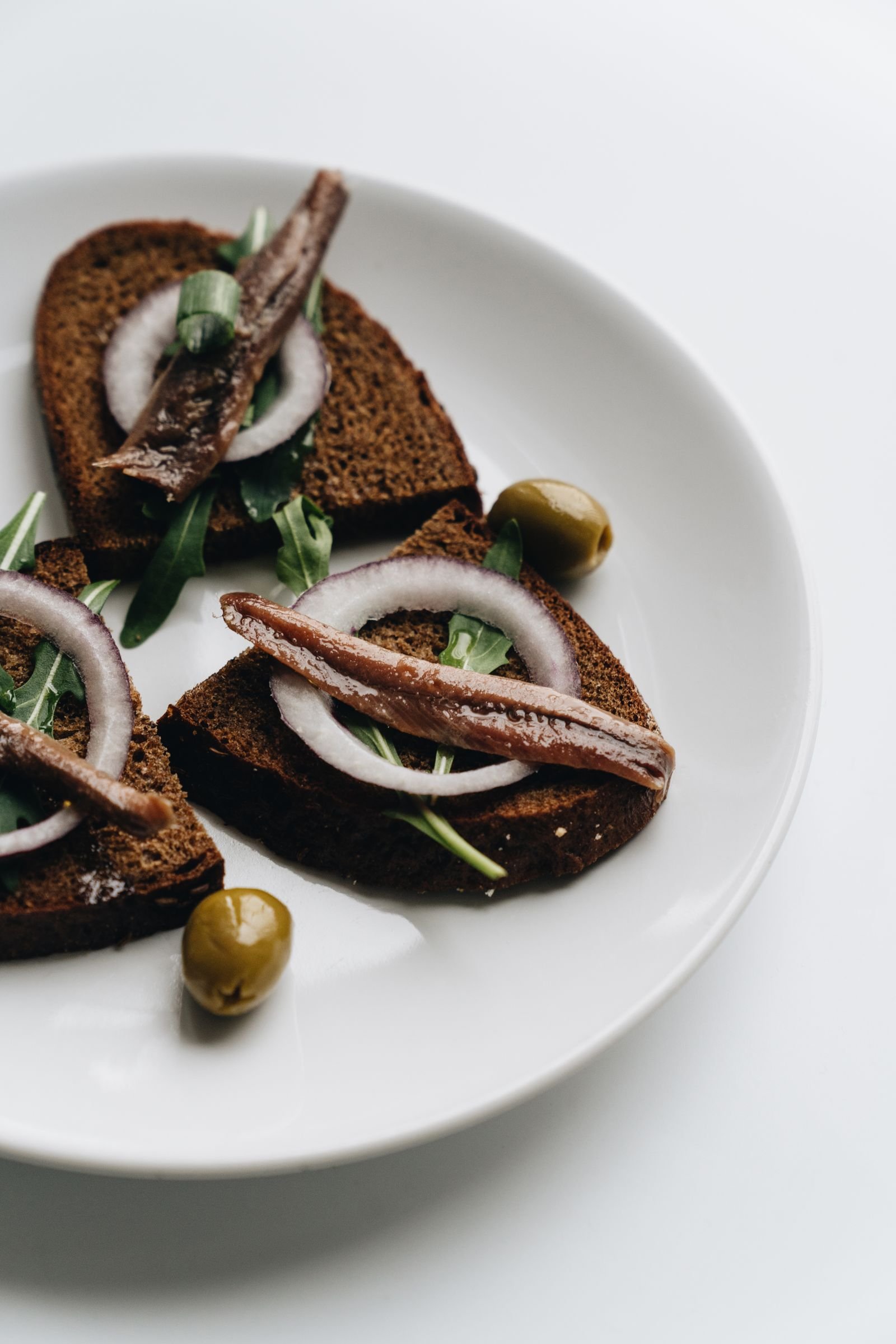 Anchovy Rye Toasts with Red Onion and Olives