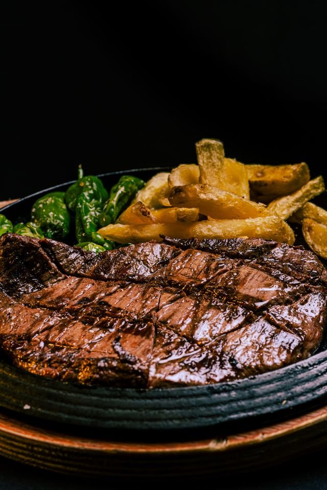 Sizzling Steak with Fries and Blistered Padron Peppers