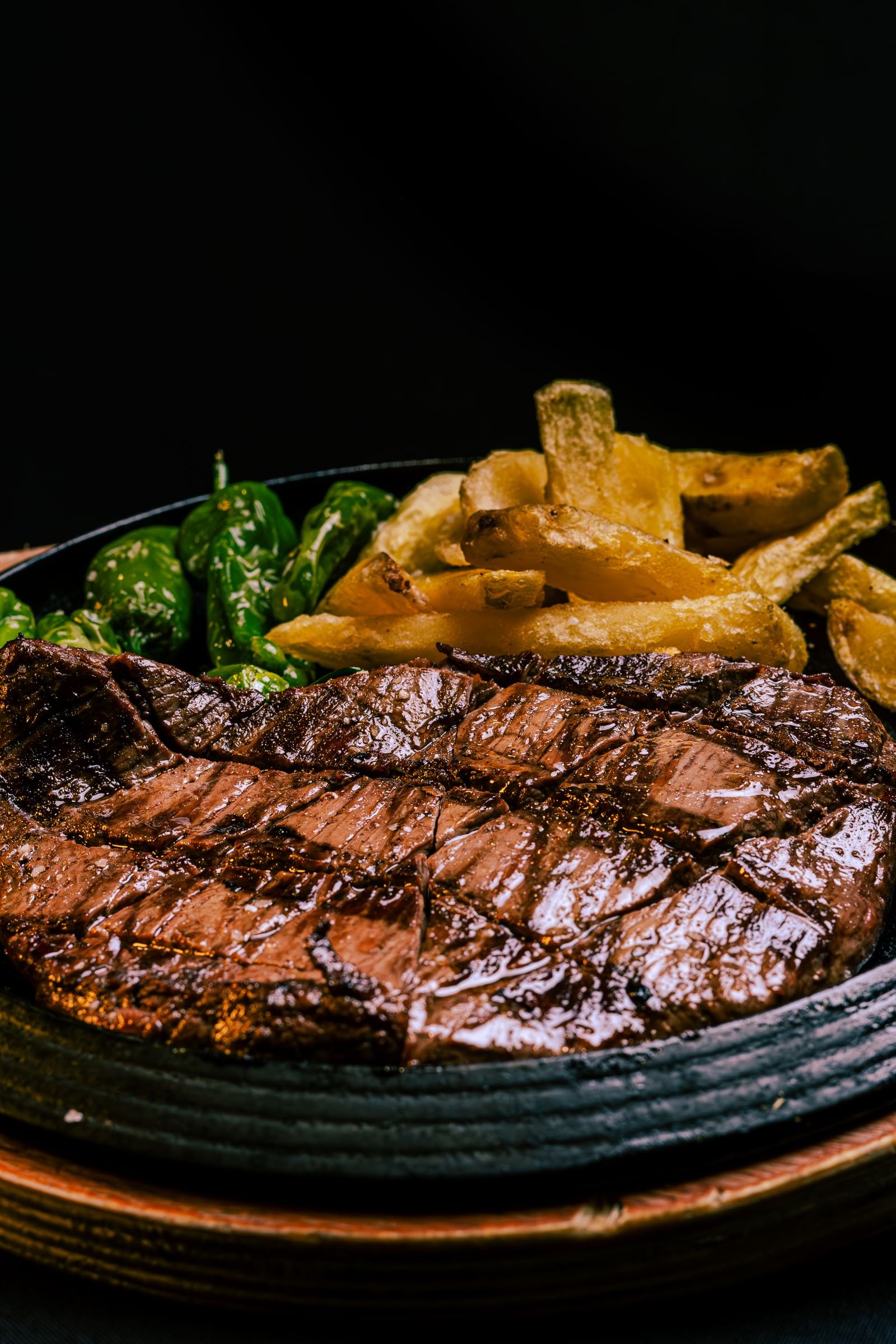 Sizzling Steak with Fries and Blistered Padron Peppers